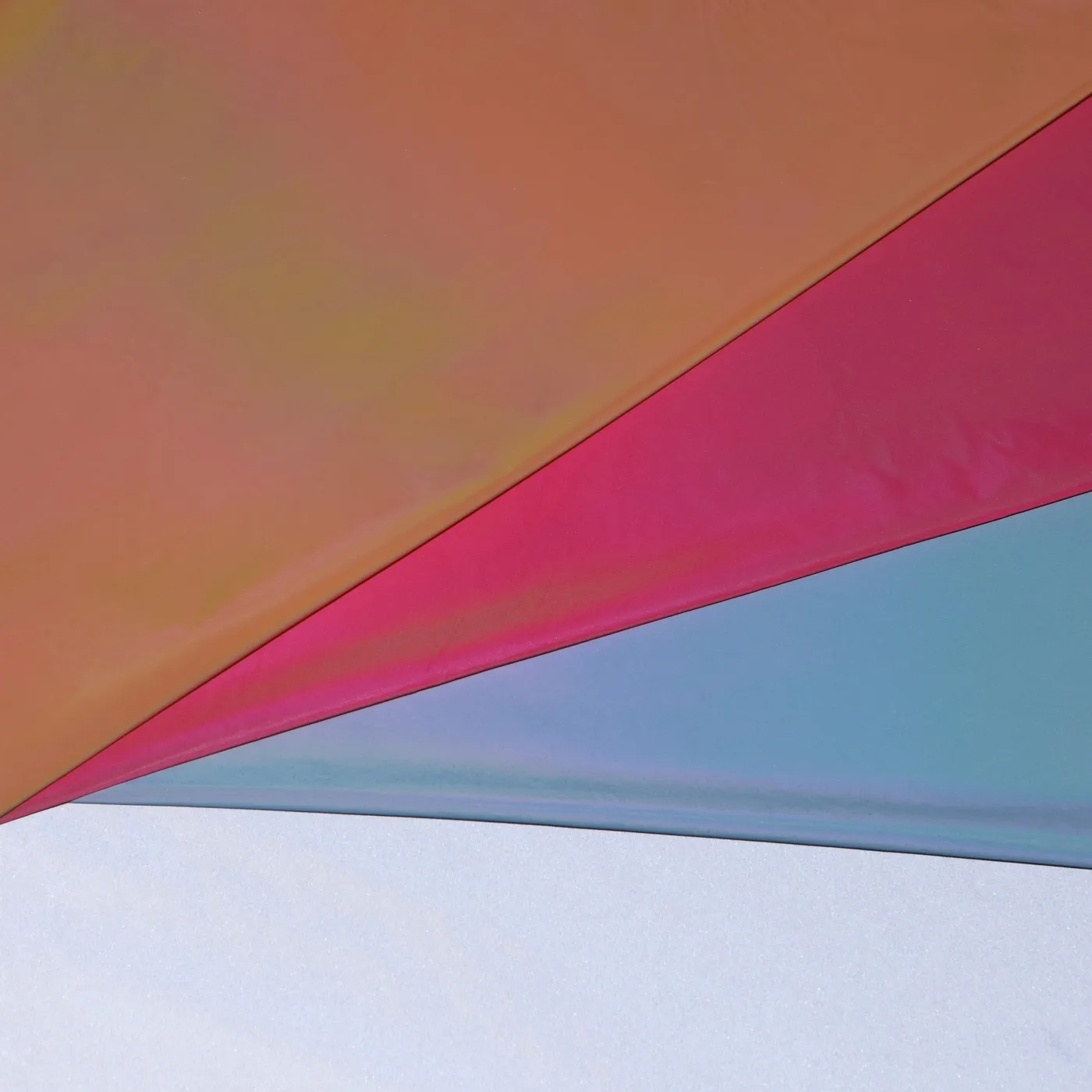Colored reflective fabric in orange, magenta and pale blue colourways over a silver coated sheet